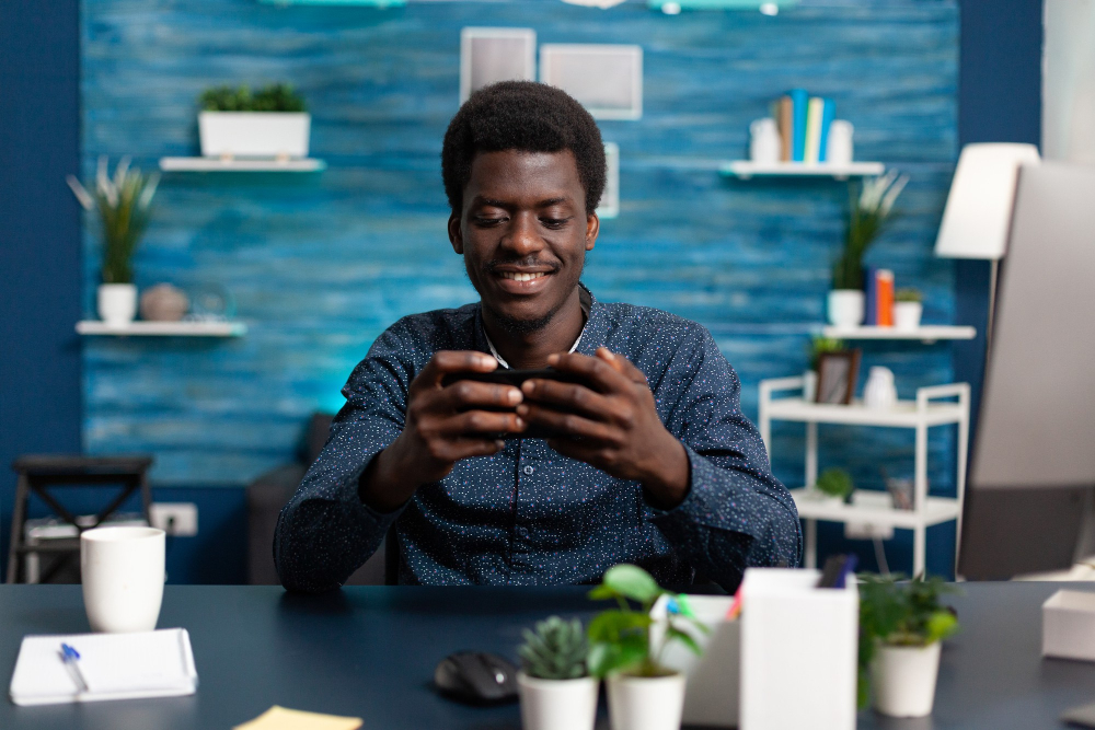 Man smiling while using his smartphone